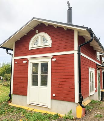 Fasad med halvmåneformat fönster med spröjs och pardörrar med glas som ger extra ljusinsläpp.
