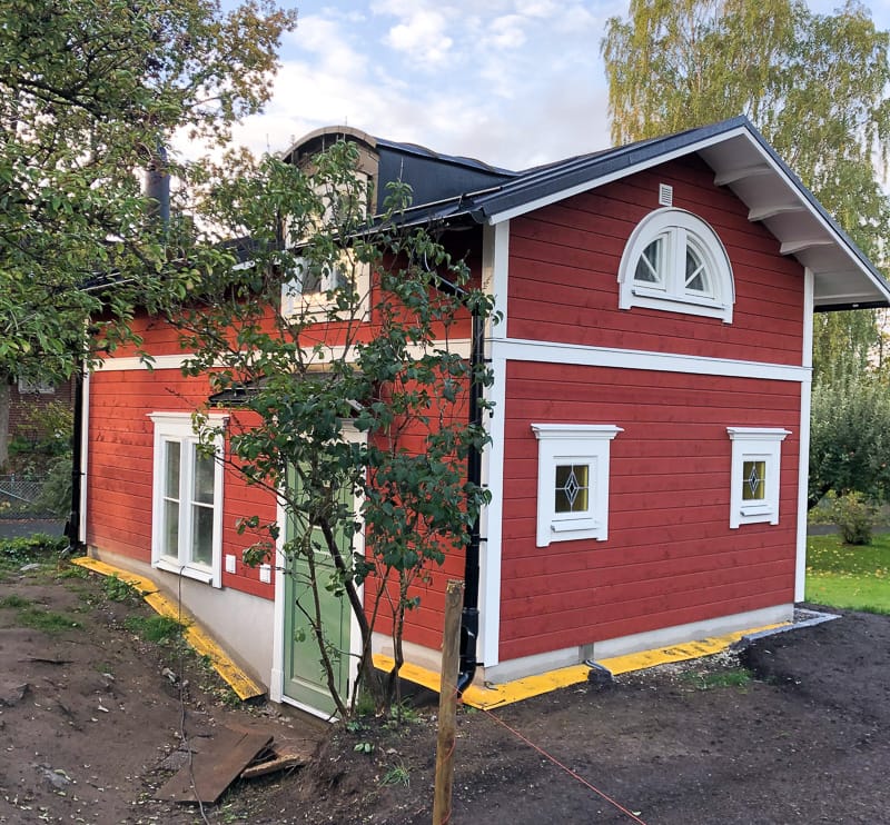 Husfasad med små fönster där diamantformade glasfält/blyinfattning fångar ljuset och syns tydligt i rutorna.