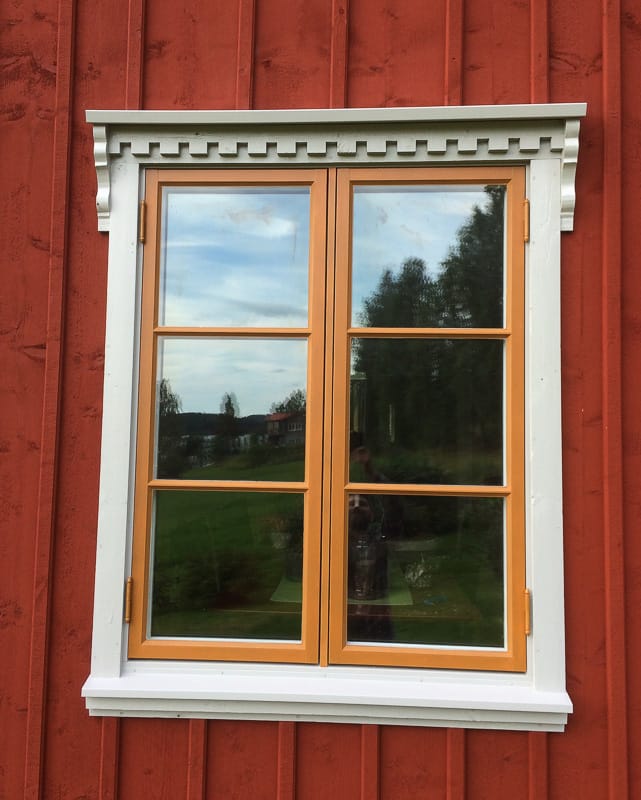 2-luftigt fönster med horisontell spröjs som delar glaset i fält och speglar omgivningen i rutorna.