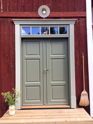 Pardörr med överljus med små glasrutor som släpper in dagsljus och ger en tydlig fönsterindelning ovanför dörren.