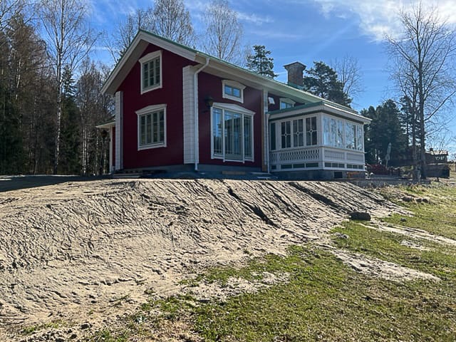 Sidovy av hus med veranda, spröjsade fönsterpartier och glasade dörrar som skapar ljus inomhus